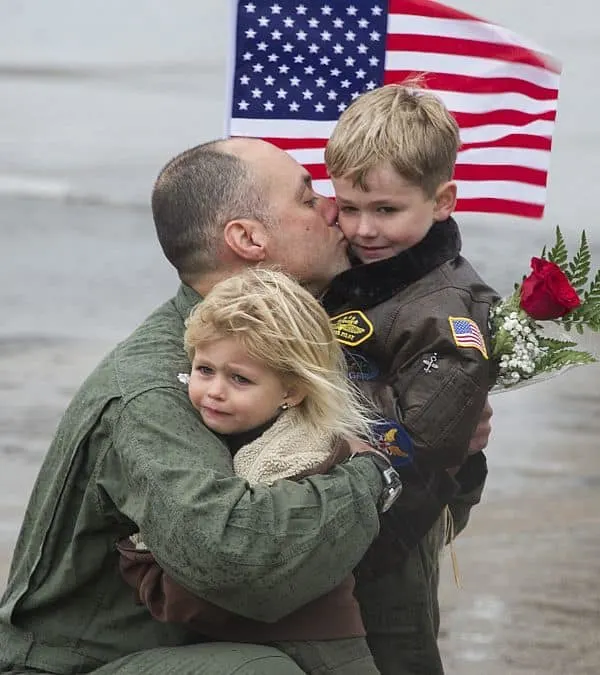 151122-N-YR571-153 VIRGINIA BEACH, Va. (Nov. 22, 2015) A pilot assigned to Strike Fighter Squadron (VFA) 136, the “Knighthawks,” hugs his kids during the squadron’s homecoming. The squadron returned as part of Carrier Air Wing (CVW) 1 following a more than nine-month deployment aboard the aircraft carrier USS Theodore Roosevelt (CVN 71). (U.S. Navy photo by Mass Communication Specialist 2nd Class Kevin F. Johnson/Released)