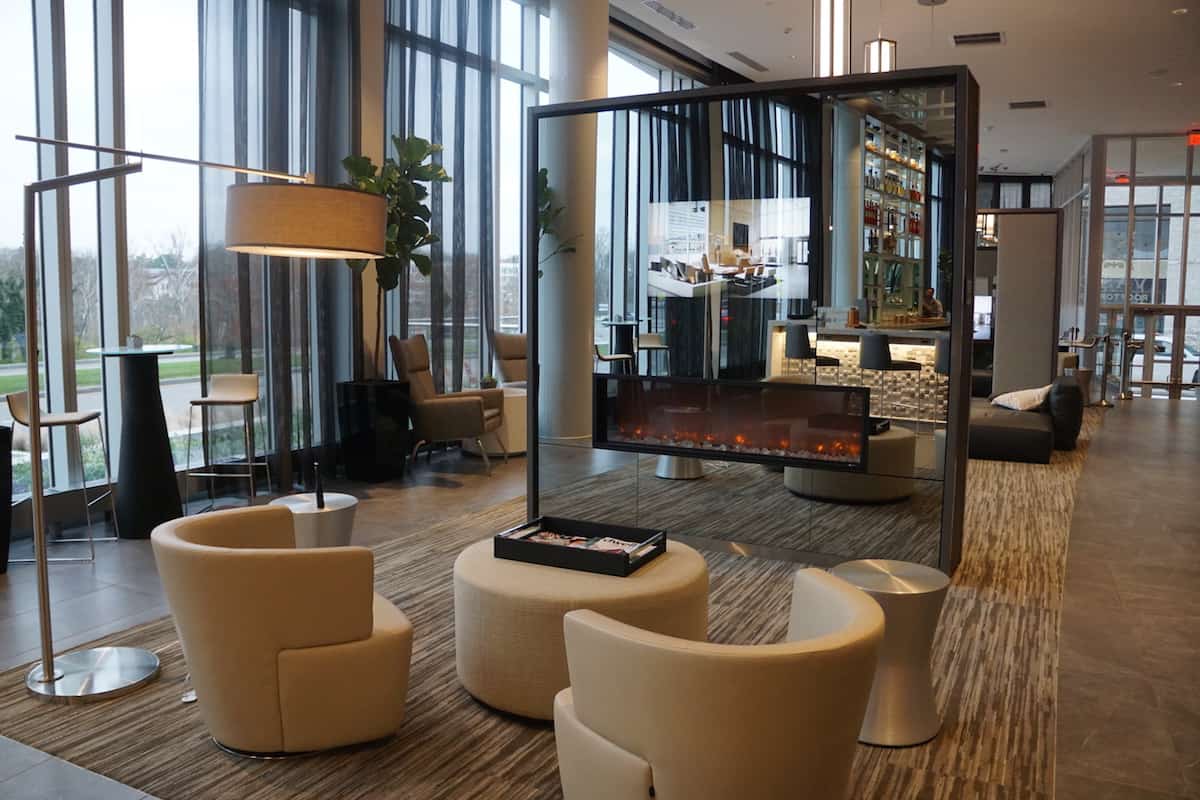 Relax in a leather chair while enjoying a glass stone fireplace and sipping a cocktail or two. | AC Hotel Columbus Dublin | TravelingWellForLess.com