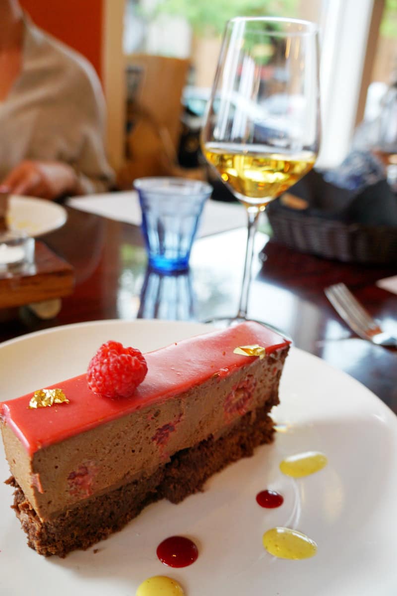 Double layer raspberry mousse and chocolate cake, separated by a slice of chocolate and topped with gold leaf. | Bellingham, WA | where to eat in Bellingham, WA | farm to table | french restaurant | TravelingWellForLess.com 