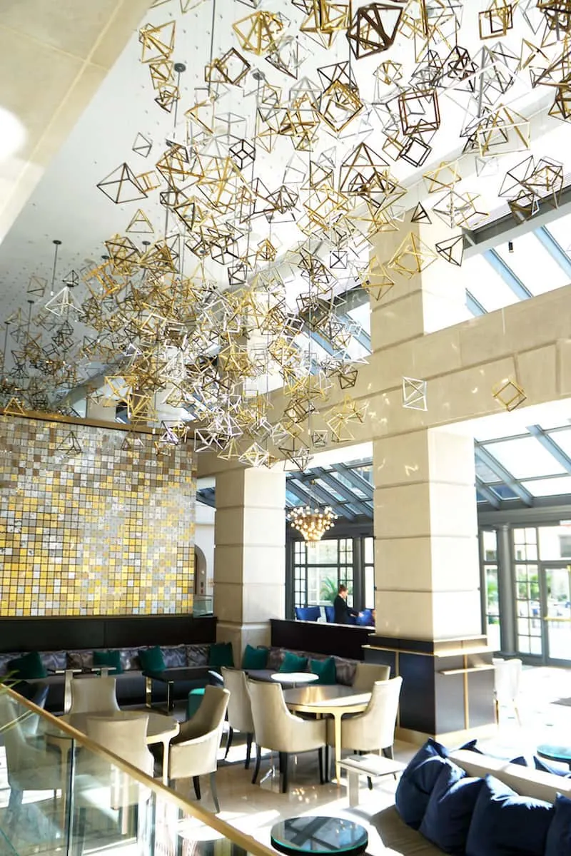 The lobby of the Fairmont Washington DC is an explosion of metal. The tri-colored geometric charms take your breath away. Can you guess the number of charms? | Fairmont Washington DC | Fairmont Gold | luxury hotel | where to stay in Washington DC | TravelingWellForLess.com