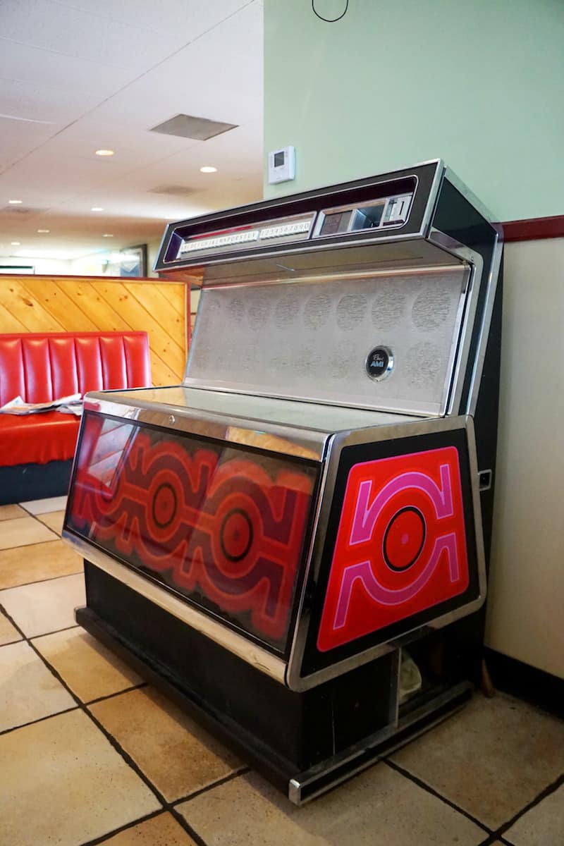 A Rowe AMI jukebox machine sits against one wall silent, unplayed. Possibly forgotten. A reminder of what once was and is no longer.