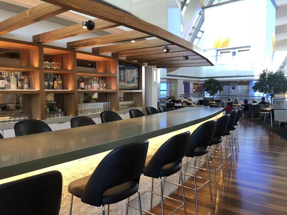 bar seating at outdoor bar overlooking atrium Star Alliance Business Class Lounge LAX 