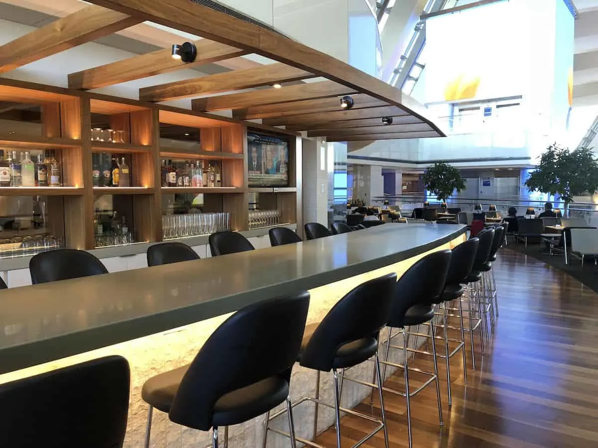 bar seating at outdoor bar overlooking atrium Star Alliance Business Class Lounge LAX