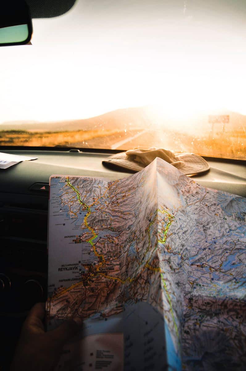 Are you tired of paying high ATM fees when you travel? Looking for a cheap way to exchange currency? Here's the secret...get a Charles Schwab checking account. It's one of the easiest, cheapest, and safest ways to get money while traveling. Image courtesy Mirza Babic via Unsplash. #travel #travelhacks #travelwell4less map of Iceland on dashboard of car