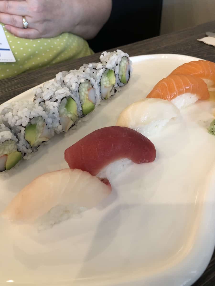 california roll and five pieces of sushi on white plate