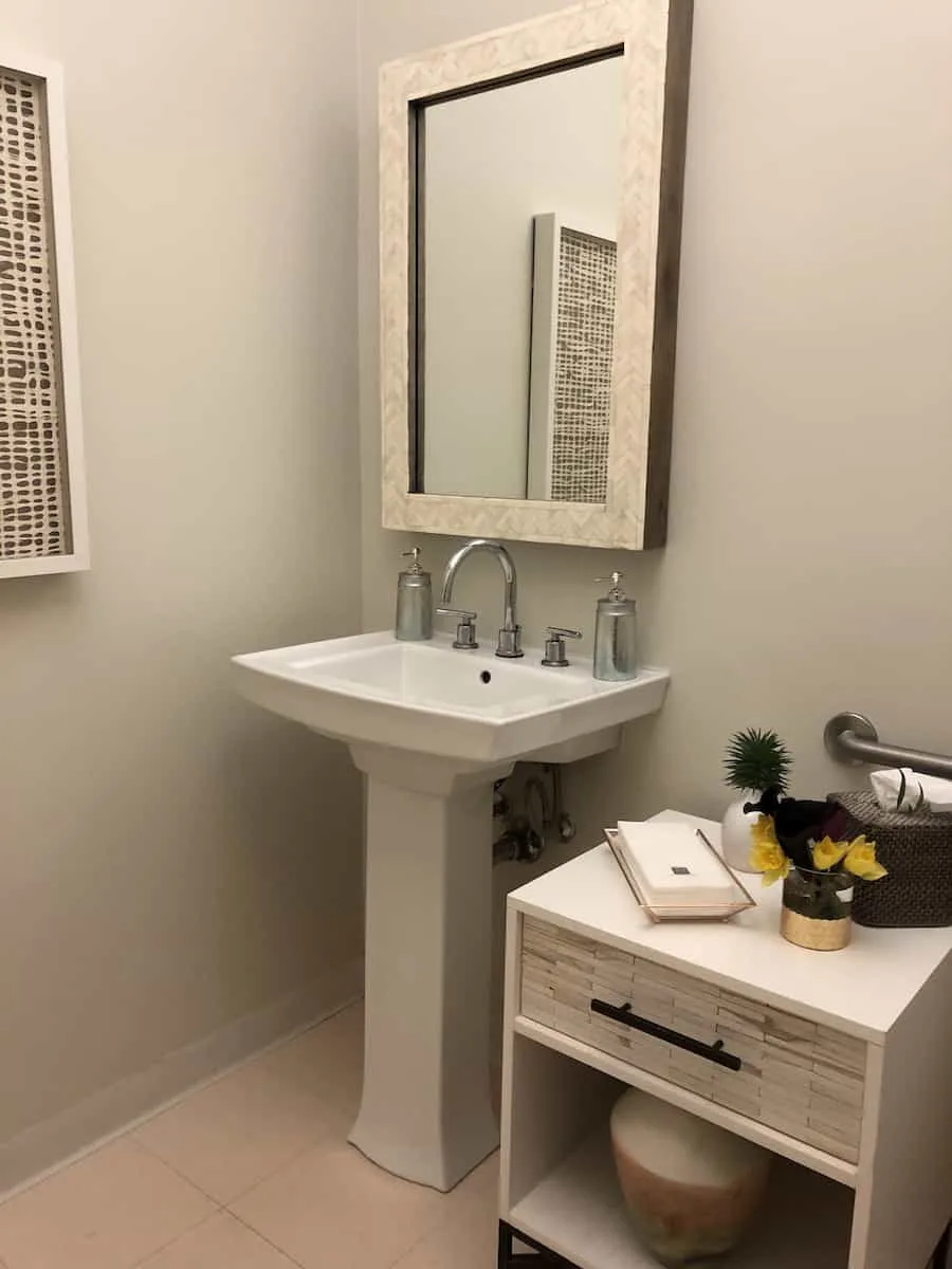 white sink, mirror, and table in access suite lounge bathroom