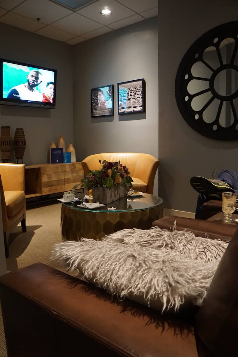 three leather chairs, a table, a sideboard, and a TV