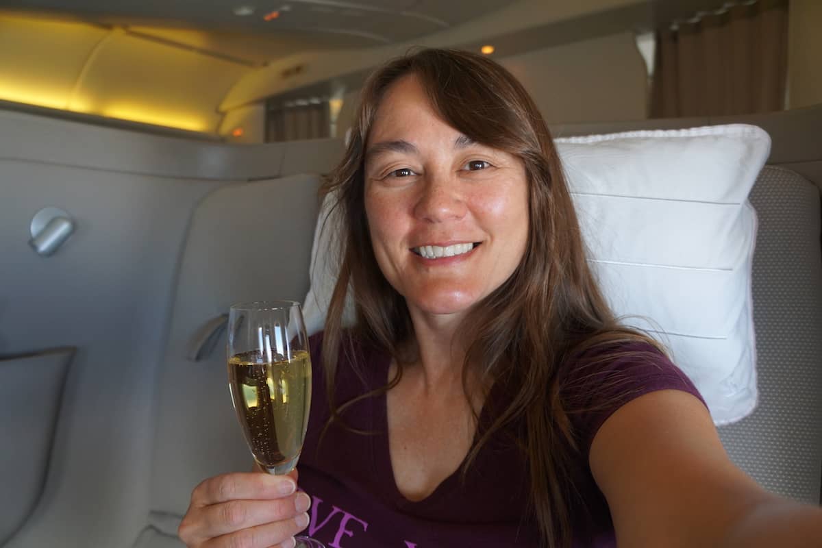 young woman holding glass of Krug champagne in Cathay Pacific First Class