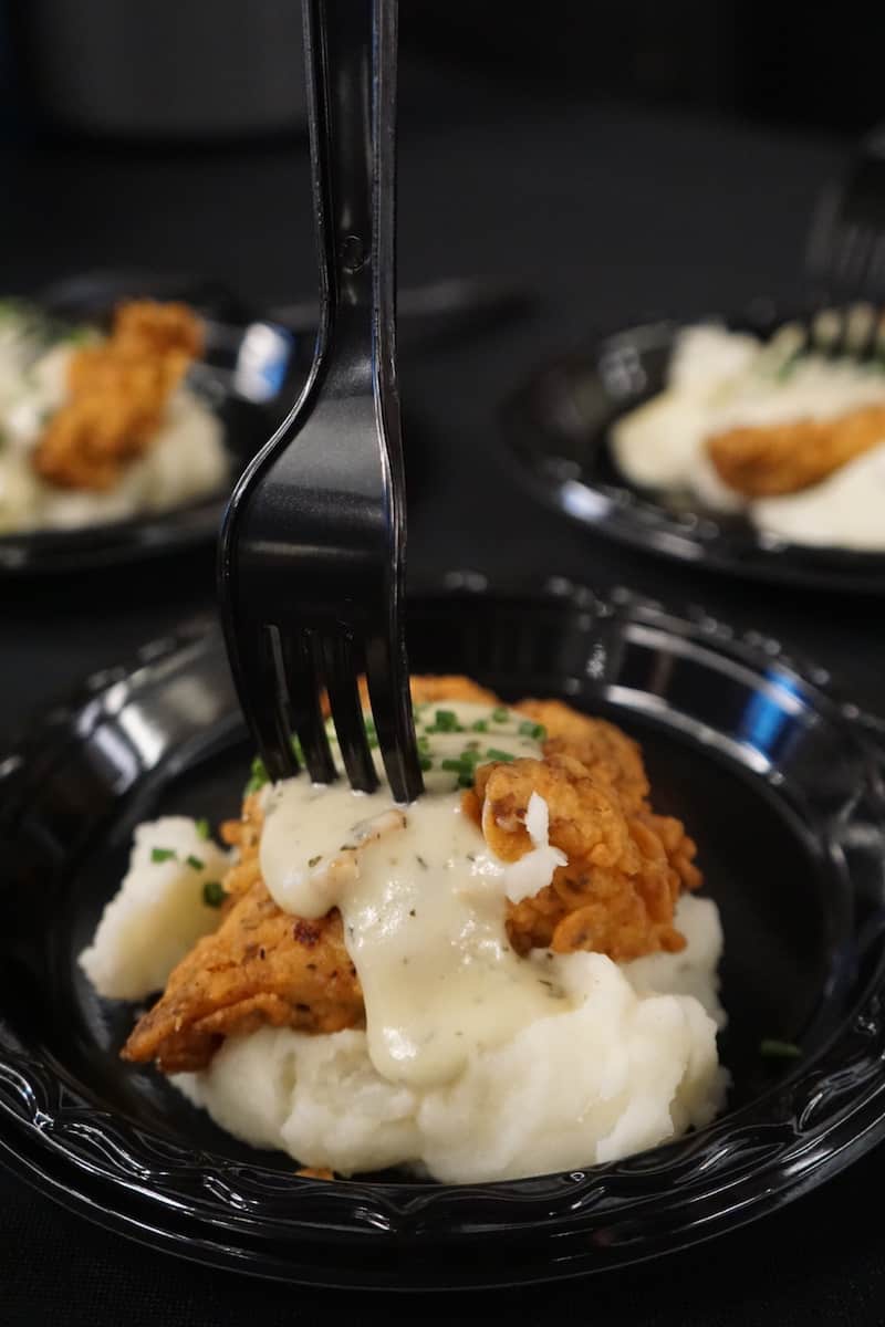 buttermilk fried chicken breast on bed of mashed potatoes