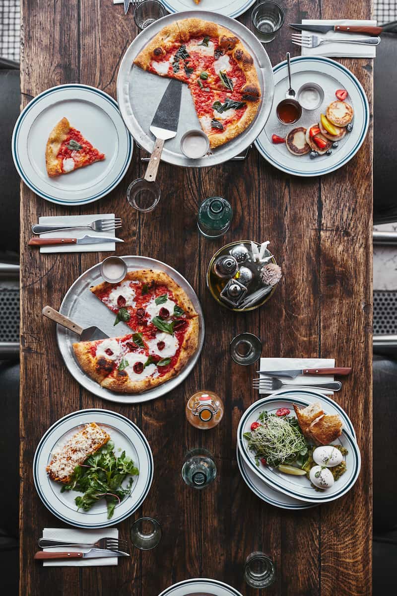 Top view of various tasty italian dishes and drinks on wooden rustic table at restaurant