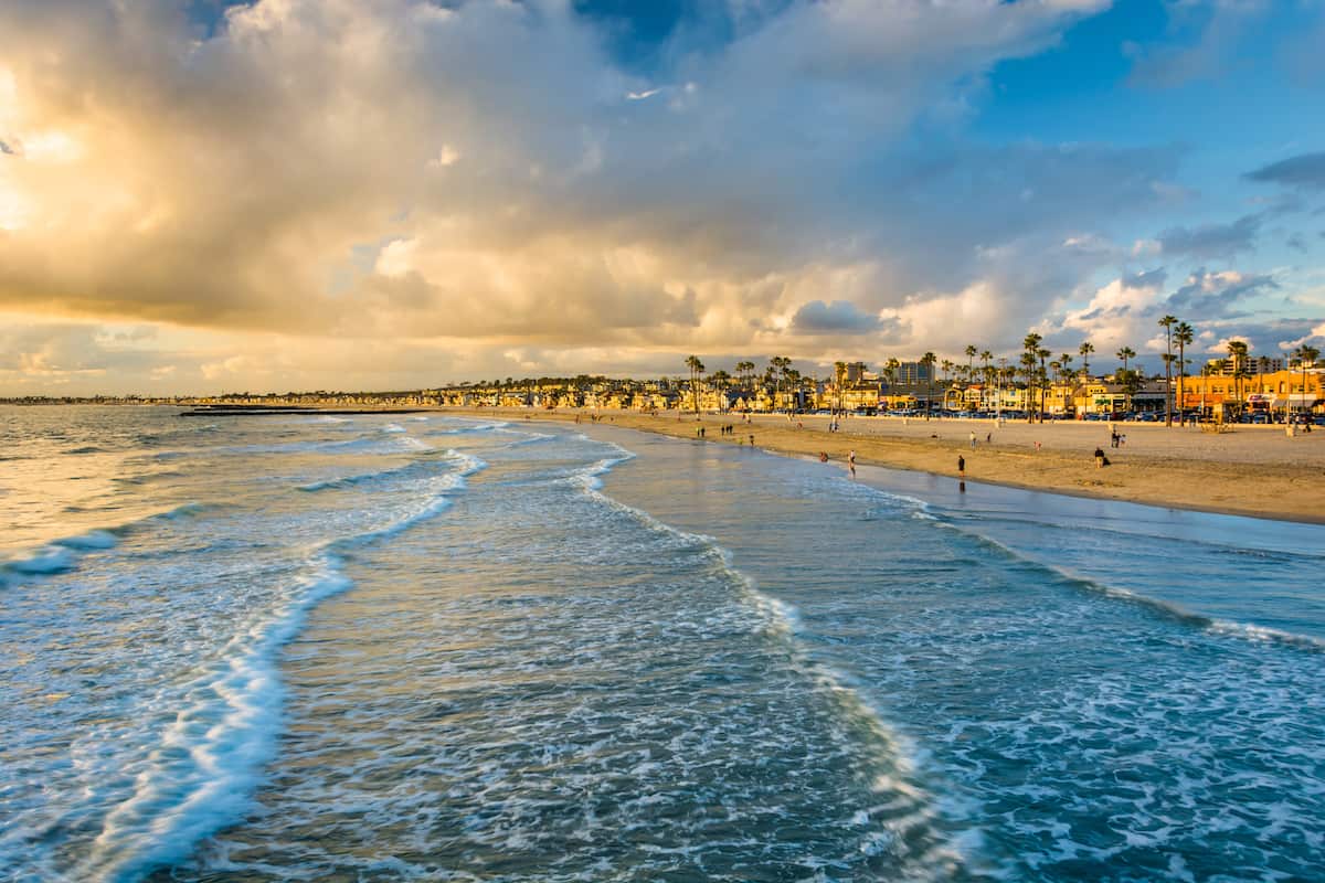 Waves in the Pacific Ocean and view of the beach at sunset, in Newport Beach, California