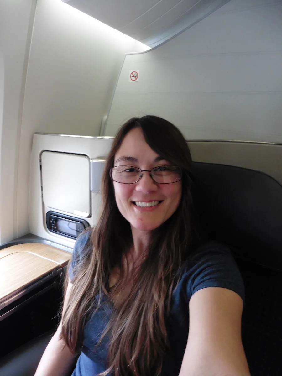 woman with brown hair sitting in First Class, Debra Schroeder flying American Airlines First Class from LHR to LAX