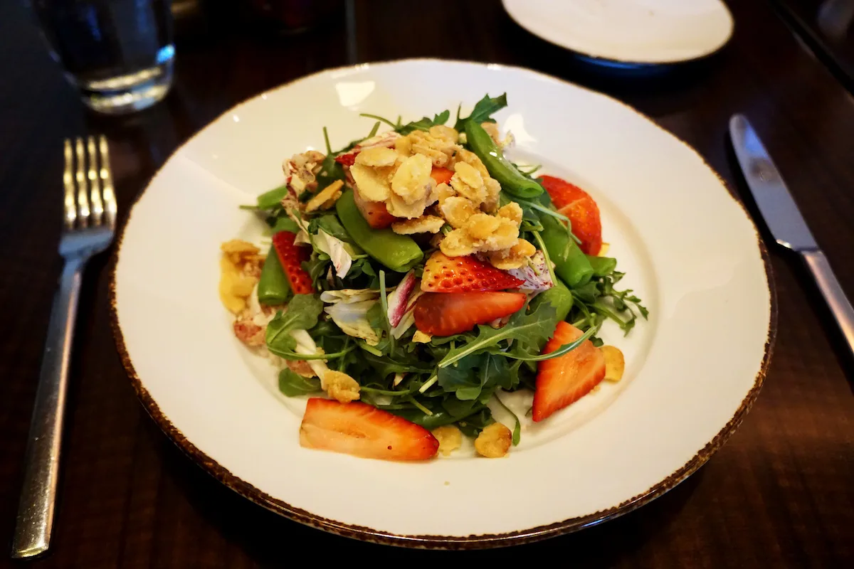 strawberry salad at Pechanga Lobby Bar and Grill at Pechanga Resort Casino. Fresh strawberries, sugar snap peas, and caramelized almonds on a bed of arugula and radicchio greens