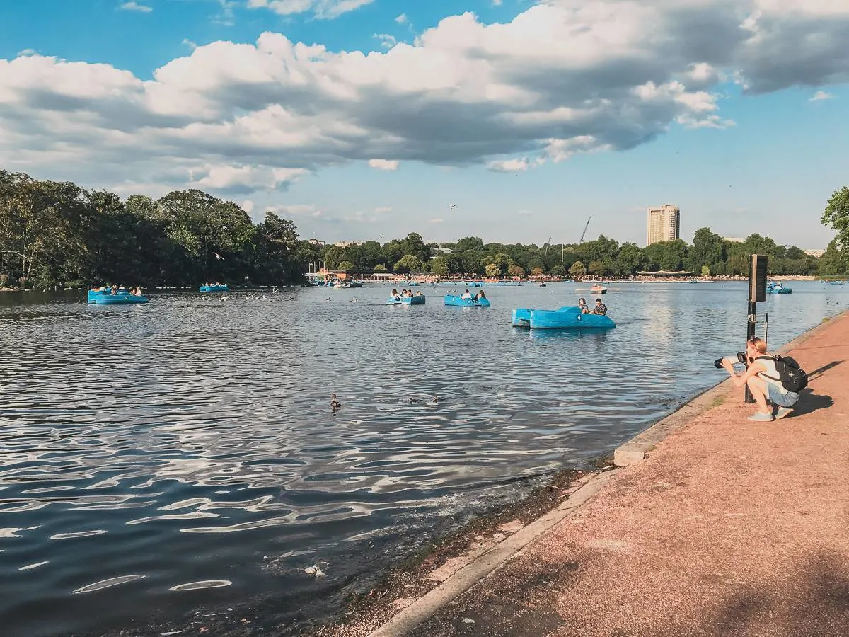 people in blue pedal boats on lake at hyde park london