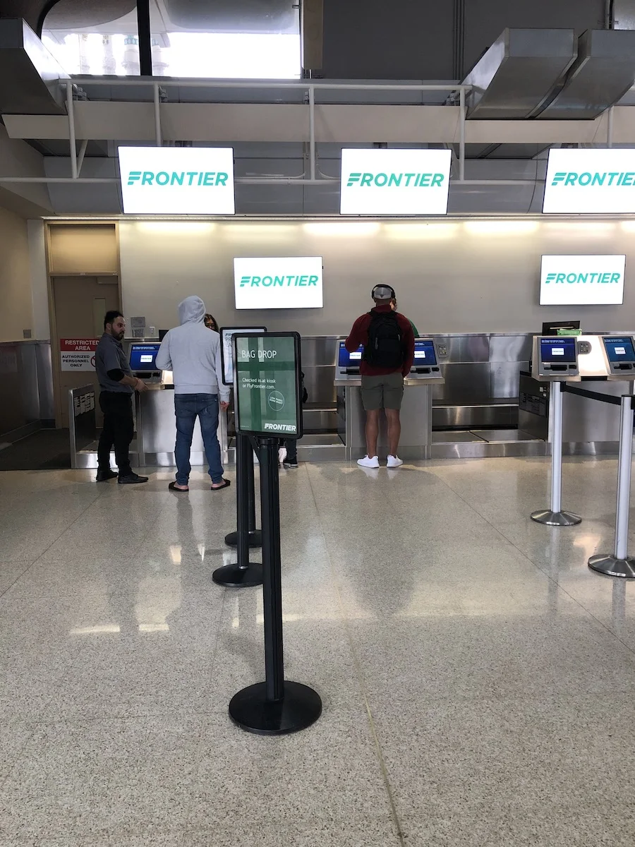 people waiting in line at Frontier Airlines counter at San Diego airport