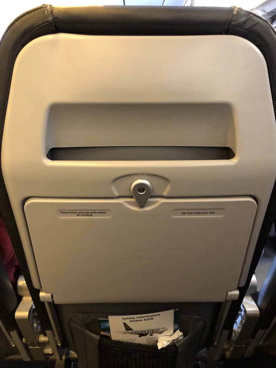 full tray table and magazine slot in seat back of airline seat