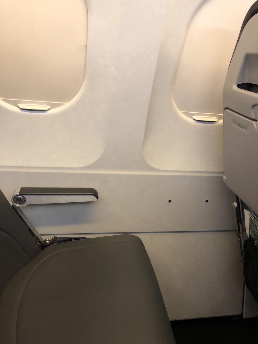 empty seat and closed window shades on airplane 