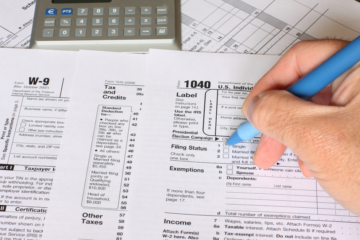 a single man filling federal tax forms with a pen