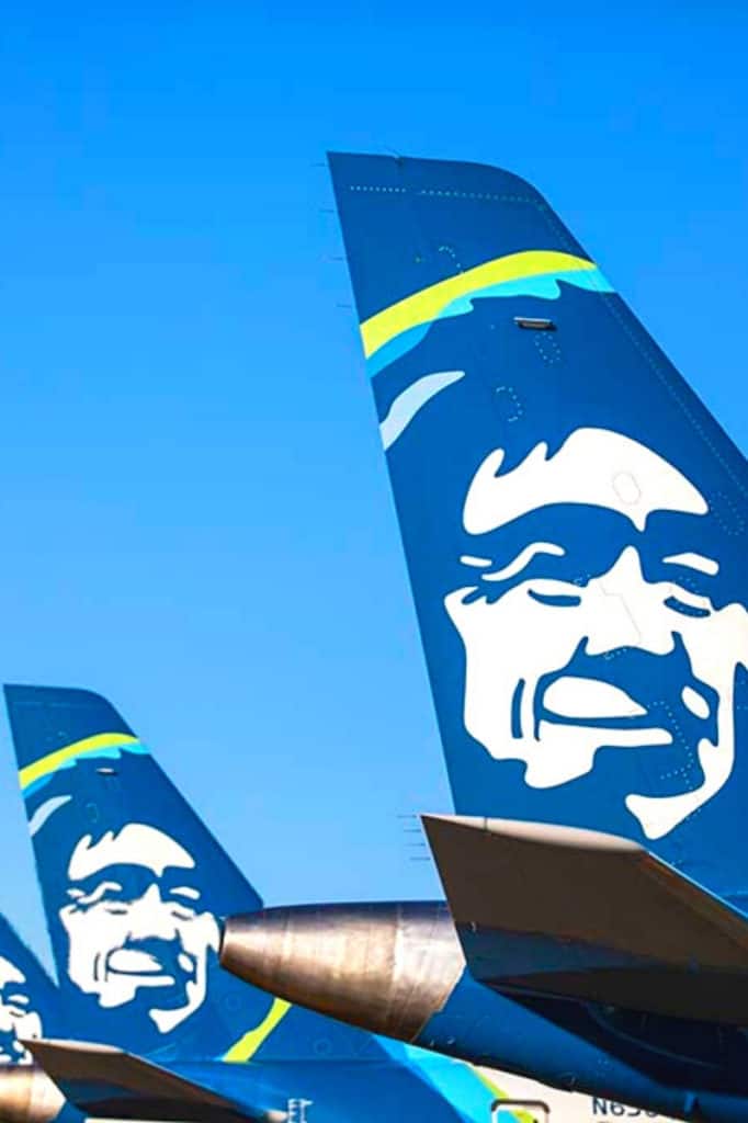 Tail of three Alaska Airlines planes lined in a row