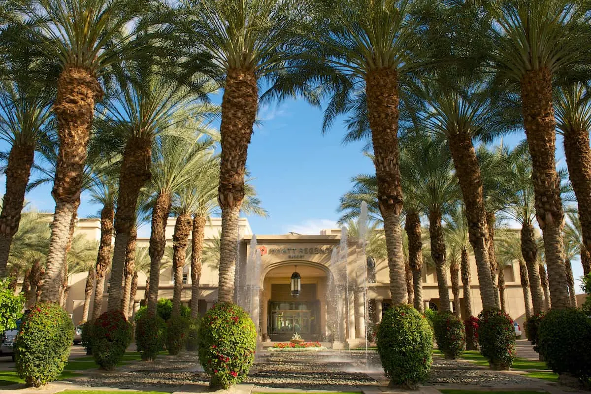 palm tree lined front of hotel