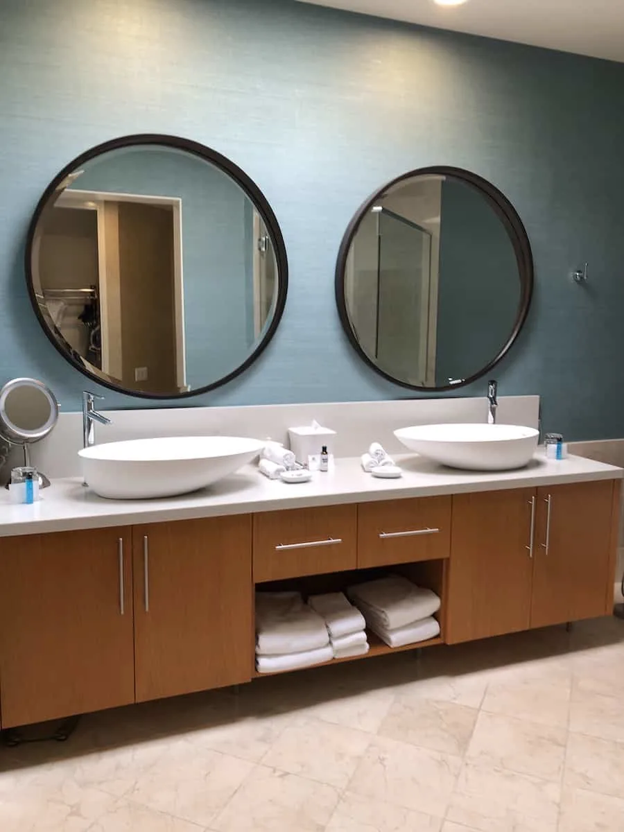 bathroom with two round mirrors and oblong countertop sinks