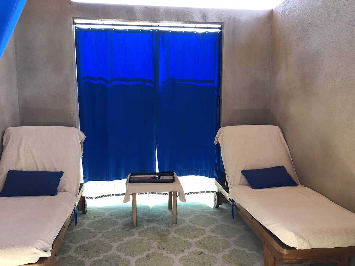 padded lounge chairs and table in pool cabana