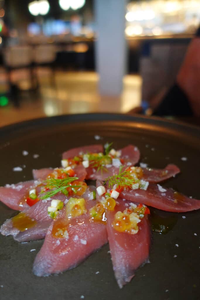 thin slices of tuna sushi on black page