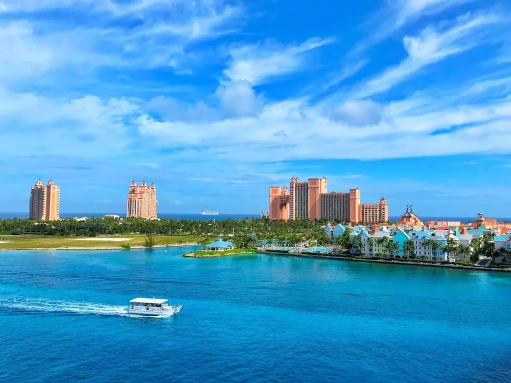 white boat on water near city buildings Atlantis Bahamas