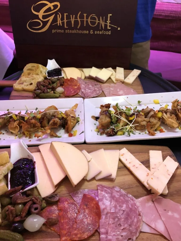 sliced meats and cheeses on wood board, charcuterie, greystone steakhouse