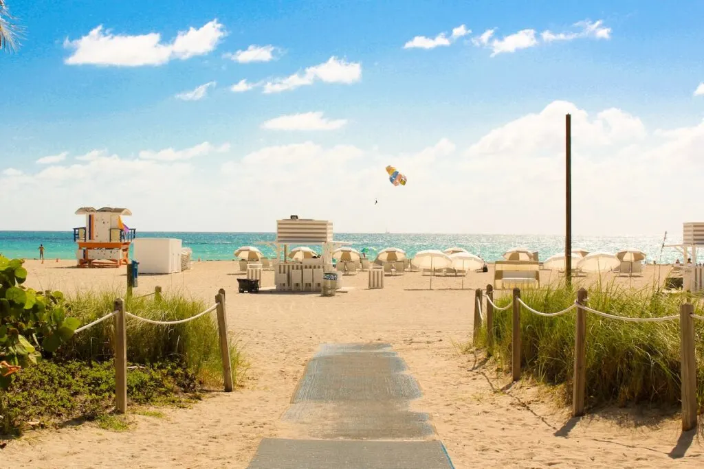 gray pathway leading to parasailing on beach in Miami