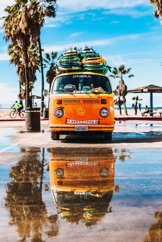 orange van with surfboard on top; earn miles and points without a credit card with car rentals