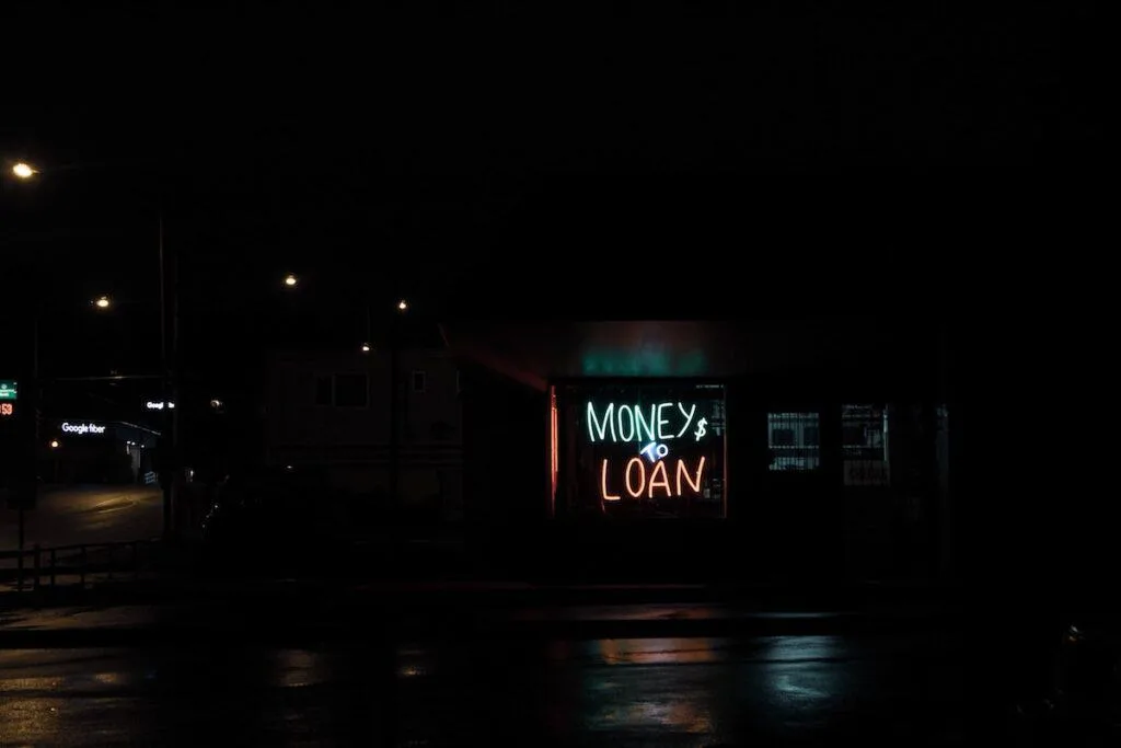 neon money to loan sign at night on a building; earn miles and points without a credit card with personal loans