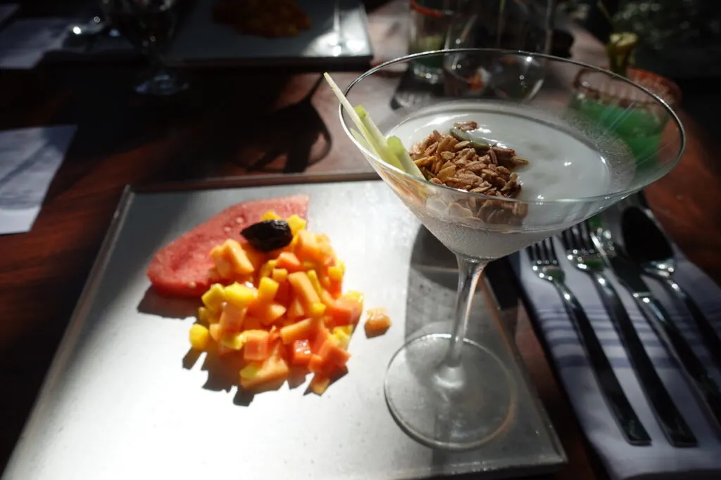 slice watermelon, chopped papaya, and martini glass with yogurt