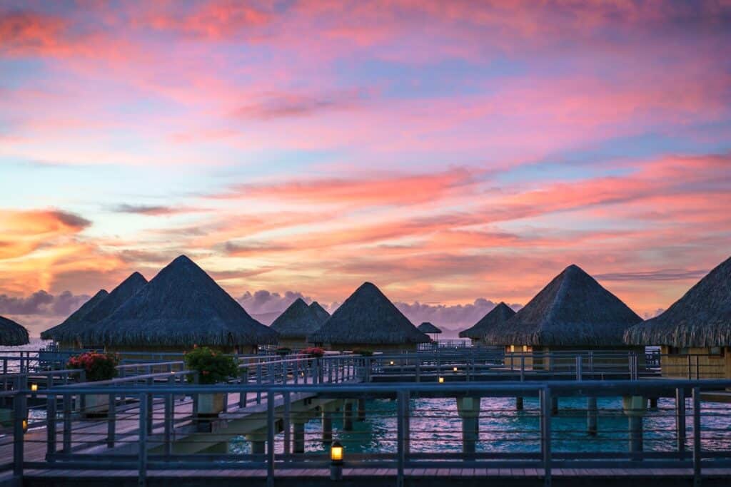 gray metal railing and huts near body of water bora bora