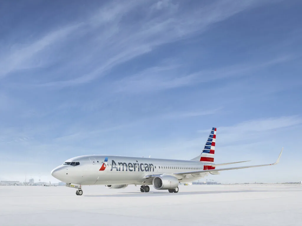 silver airplane with red, white, and blue strips on tail