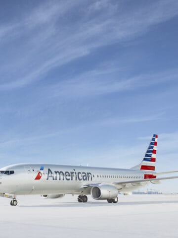 silver airplane with red, white, and blue stripes painted on tail