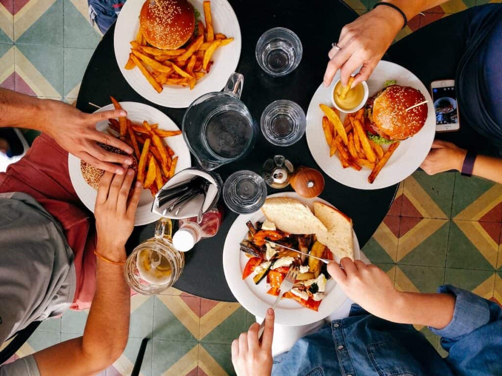 four people eating on black wooden table