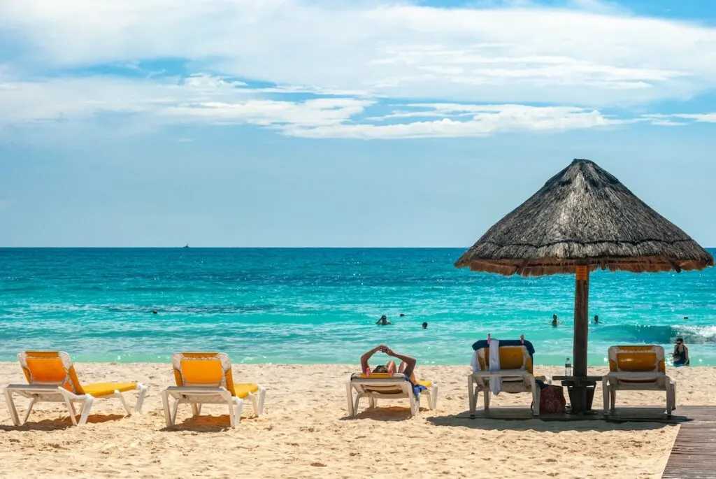 brown beach umbrellas on beach during daytime, turquoise waters of cancun quintana roo
