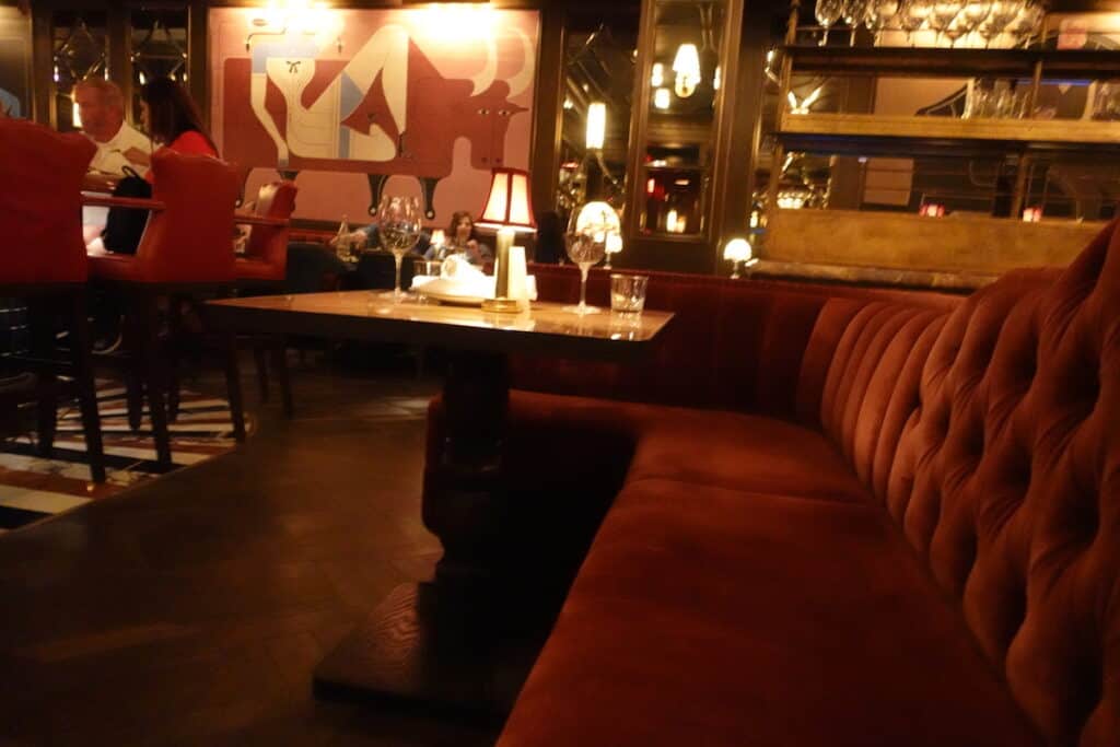 red velvet booth with brown table in dimly lit restaurant