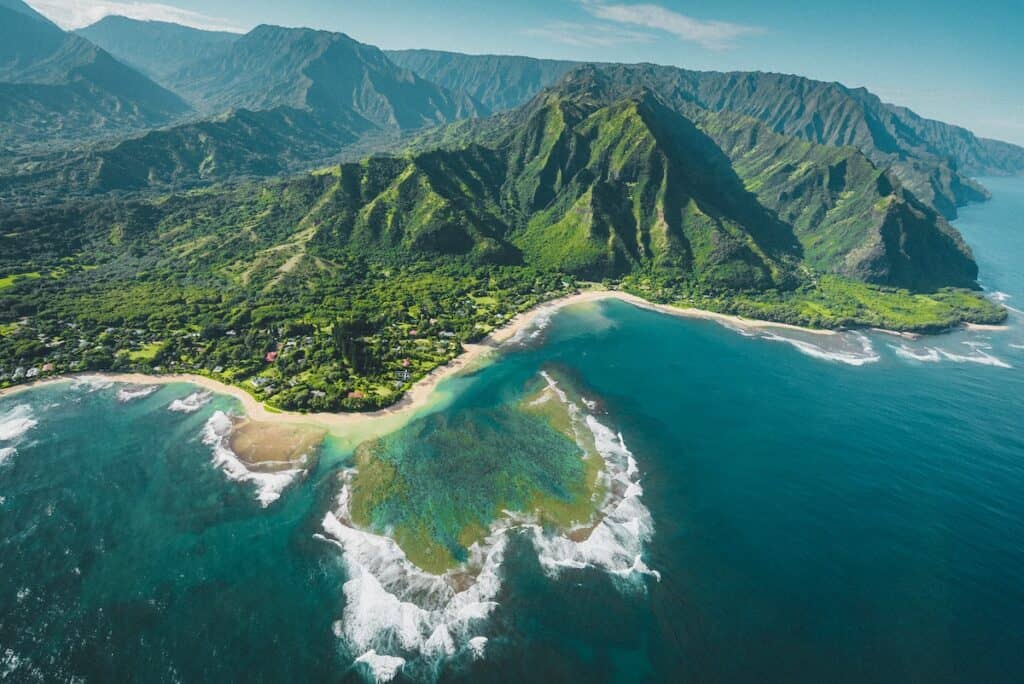 aerial view of green and brown mountains and lake and ocean Kauai Hawaii