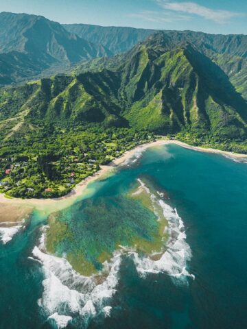 aerial view of green and brown mountains and lake and ocean Kauai Hawaii