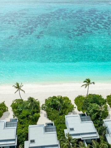 gray buildings on white sand beach, oceanfront luxury resort, Alila Korthaifaru Maldives