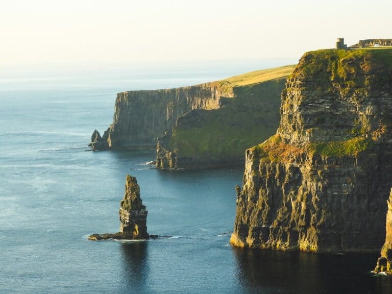 rock formation beside sea under white sky, cliffs of moher, ireland