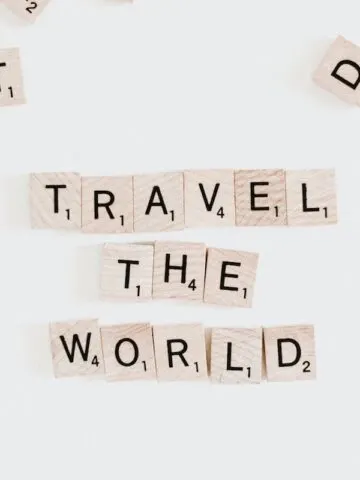 light color wood tiles with letters spelling out travel the world photo, scrabble tiles travel the world