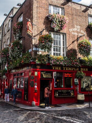 red telephone booth in front of brown concrete building temple bar dublin ireland