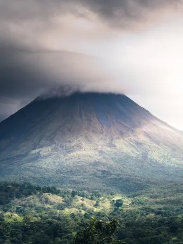 a very tall mountain with a very cloudy sky above it