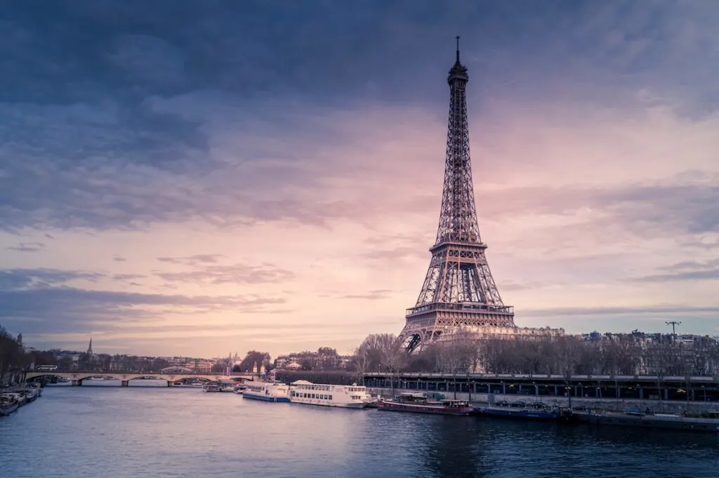 tall pointy triangular metal tower near river at sunset, Eiffel Tower, Paris France