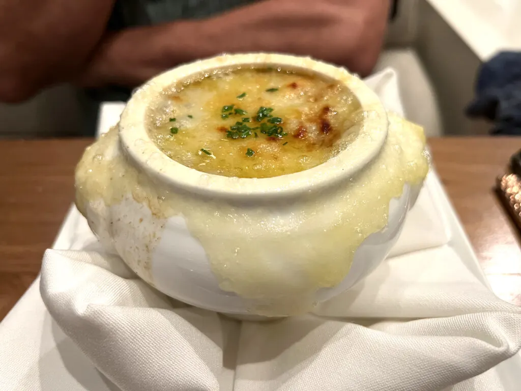 chives and melted cheese topped soup in white porcelain bowl, 17th century soup