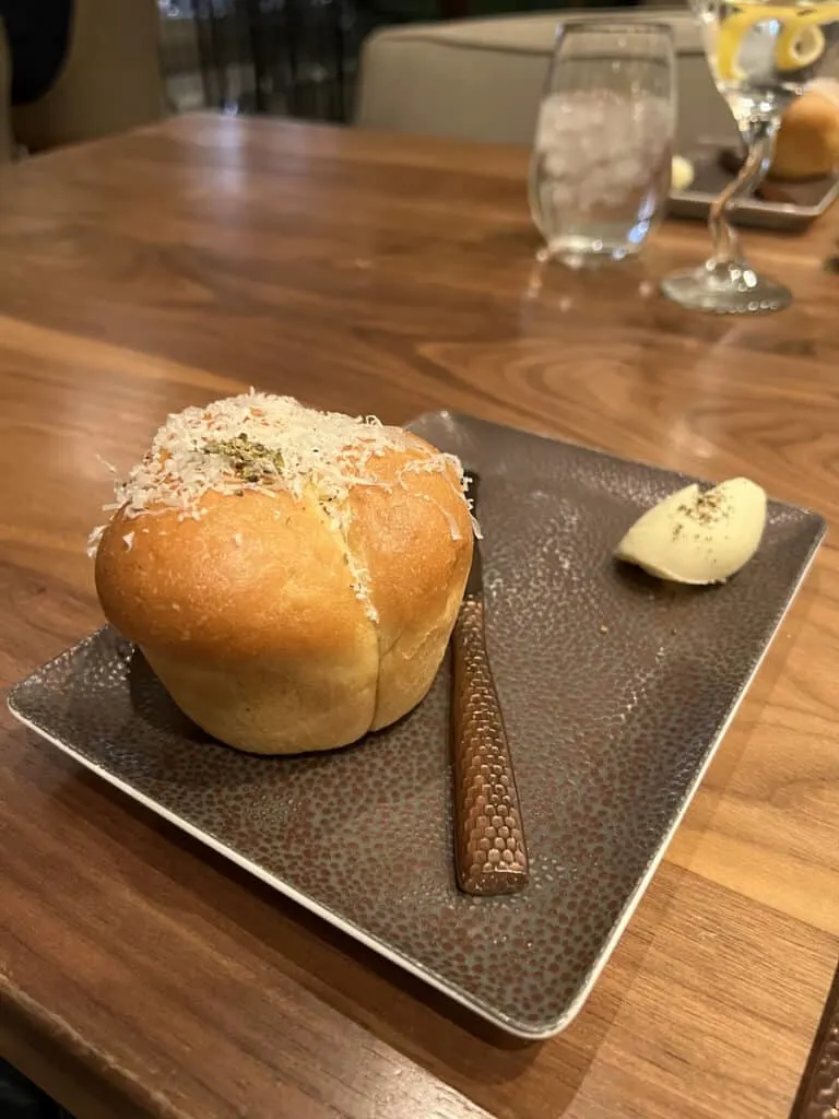 small round loaf of bread topped with shredded Parmesan cheese