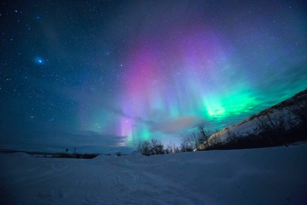 northern lights over snow-capped mountians, Tromso Norway, aurora borealis in norway